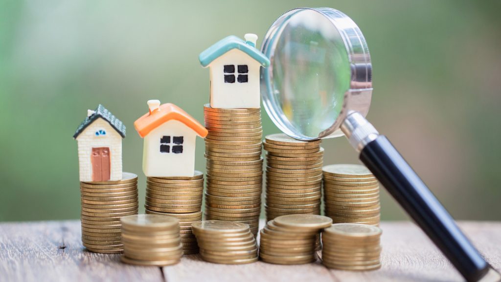 model houses on top of stacks of coins