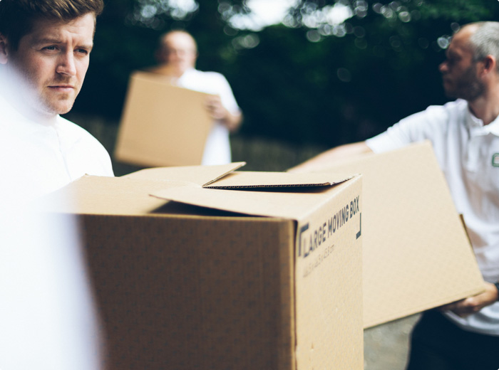 Removal staff carrying boxes to the property